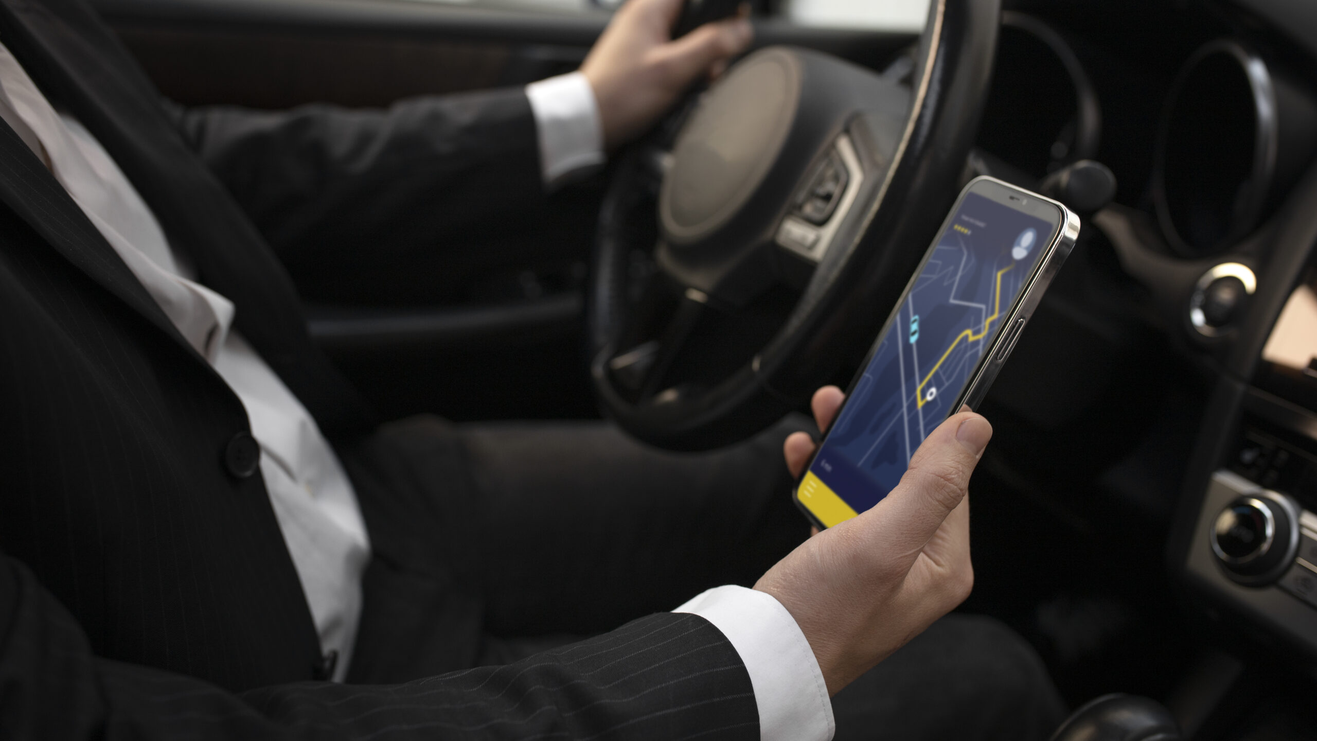 Suit-clad pro driving with navigation app. Promotes Delhi outstation corporate car hire for safe travel.